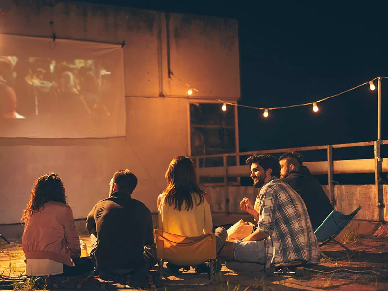 People watching a screen outside at night