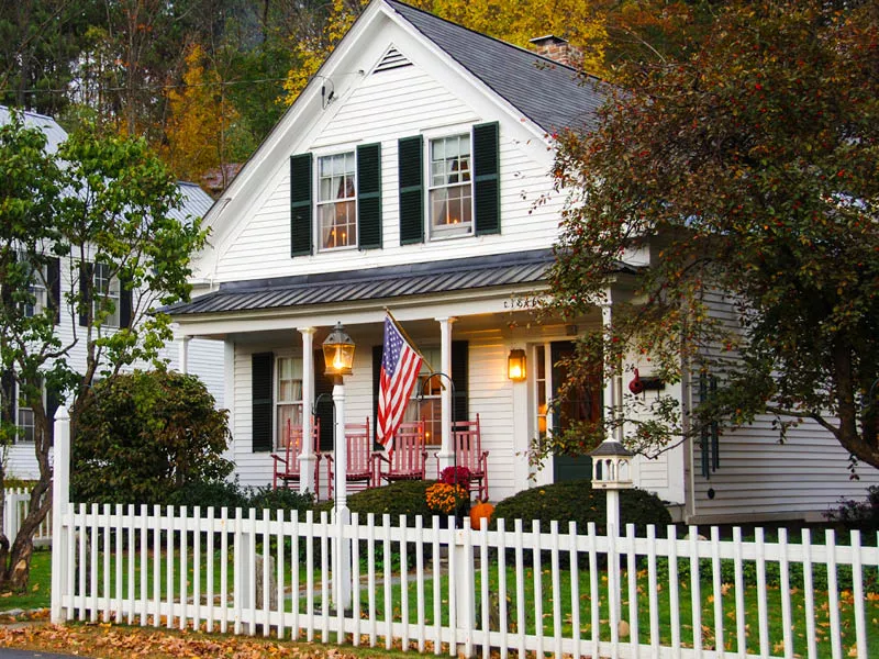 Outside of a white house with a picket fence