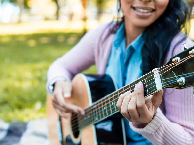 Person strumming a guitar