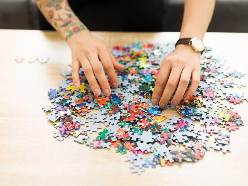 Hands on a pile of puzzle pieces