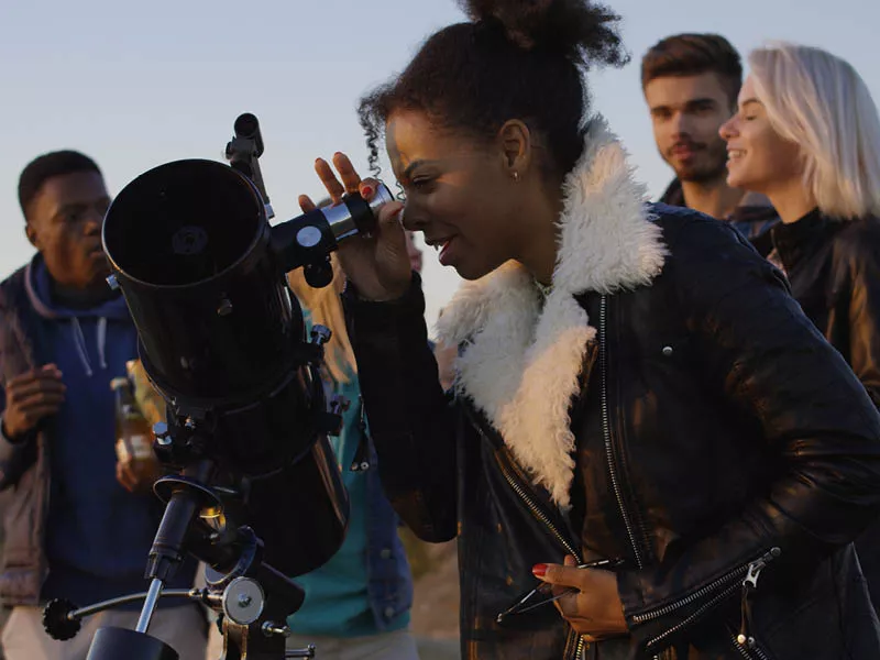 Girl looking through a telescope