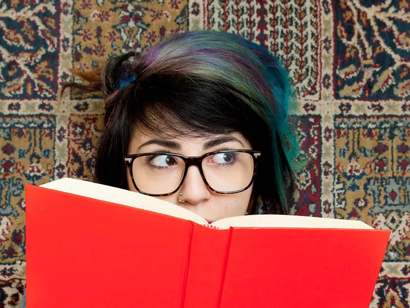 Person peering over the top of a book